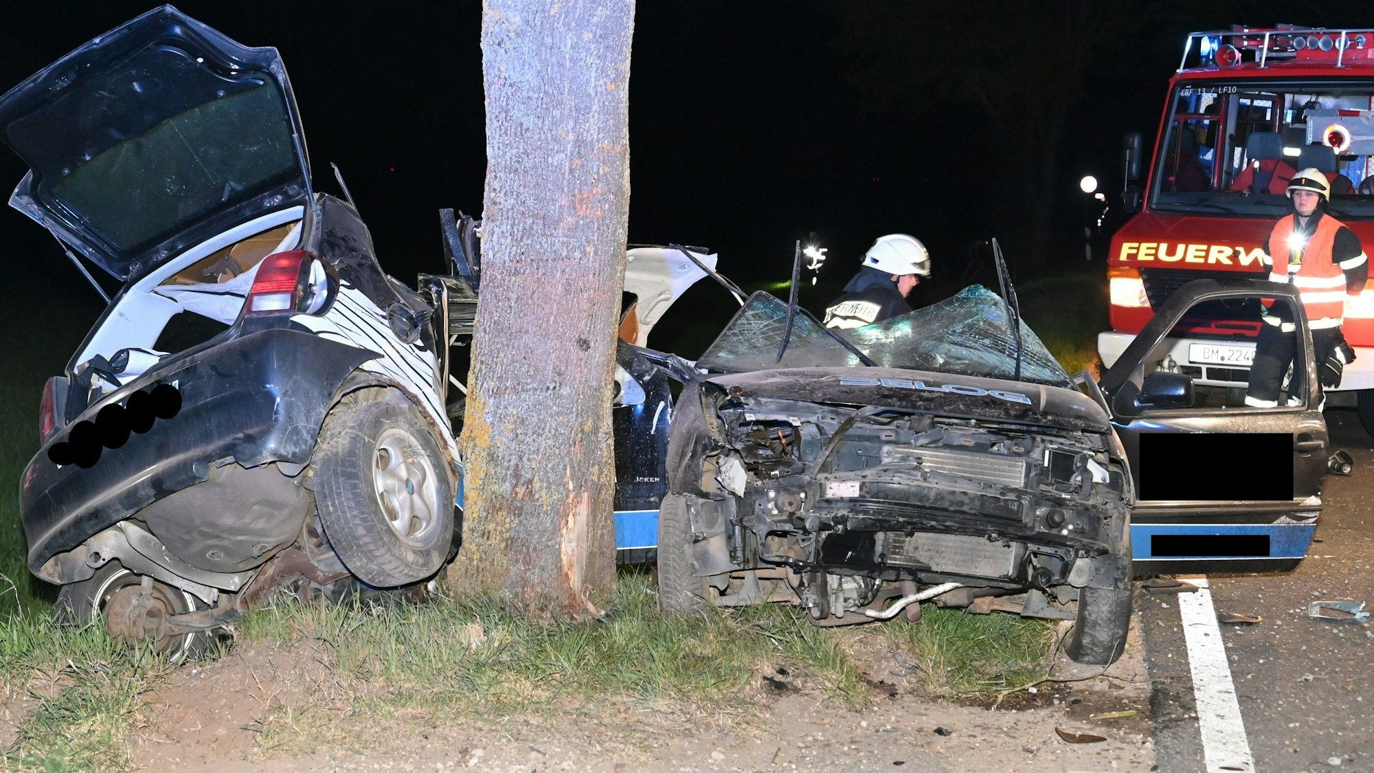 Das Bild zeigt Einsatzkräfte der Feuerwehr neben einem verunglückten Pkw.