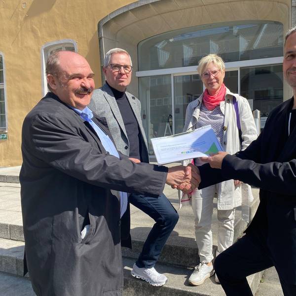 Zu sehen sind drei Mitglieder des Vereins Bovivo, die Ralf Ritter die gesammelten Unterschriften überreichen.