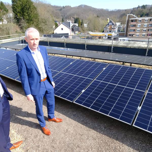 Kai Zinken (r.) und Abteilungsleiter Jörg Schröder stehen auf dem Dach neben PV-Modulen.