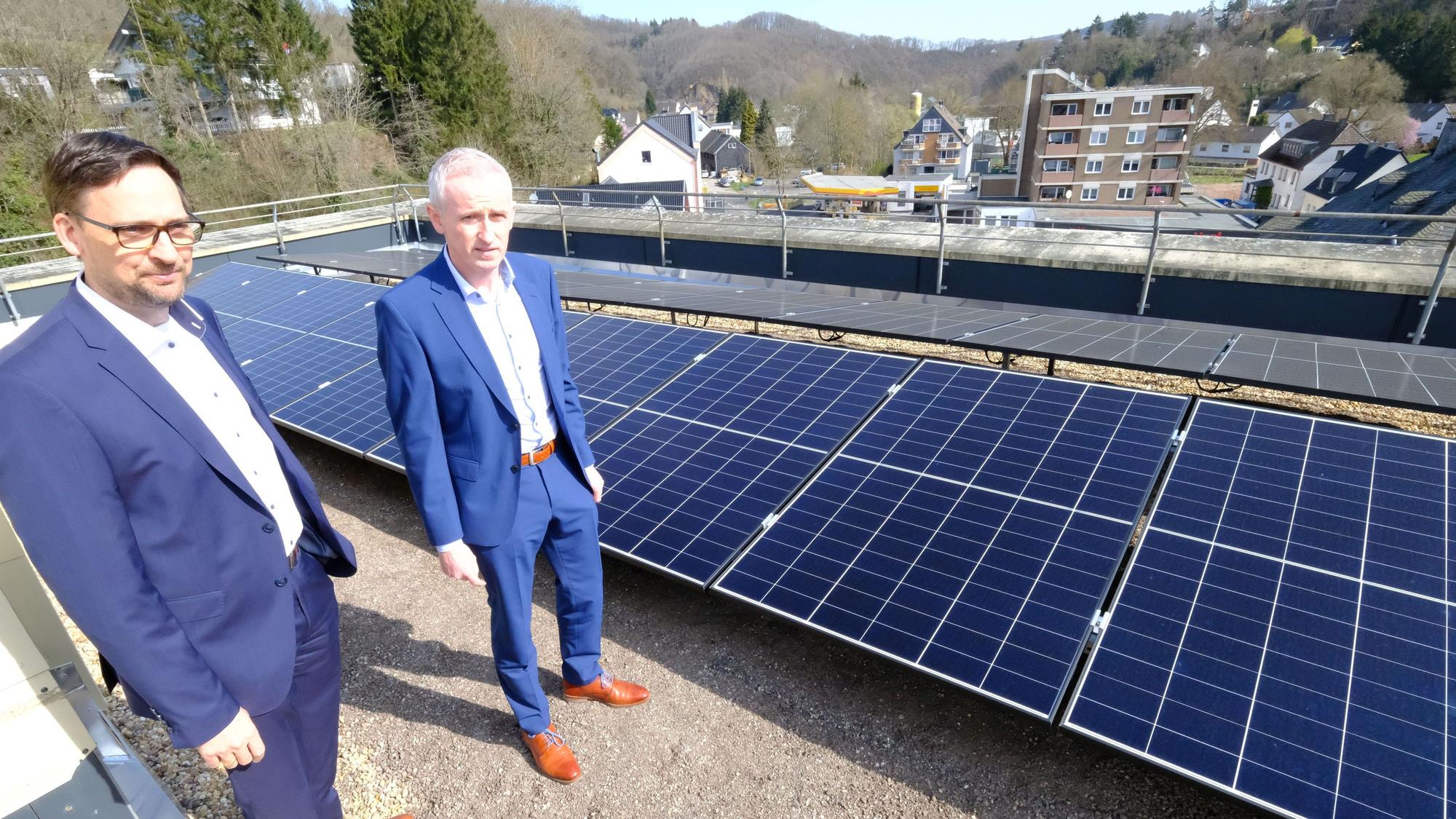 Kai Zinken (r.) und Abteilungsleiter Jörg Schröder stehen auf dem Dach neben PV-Modulen.