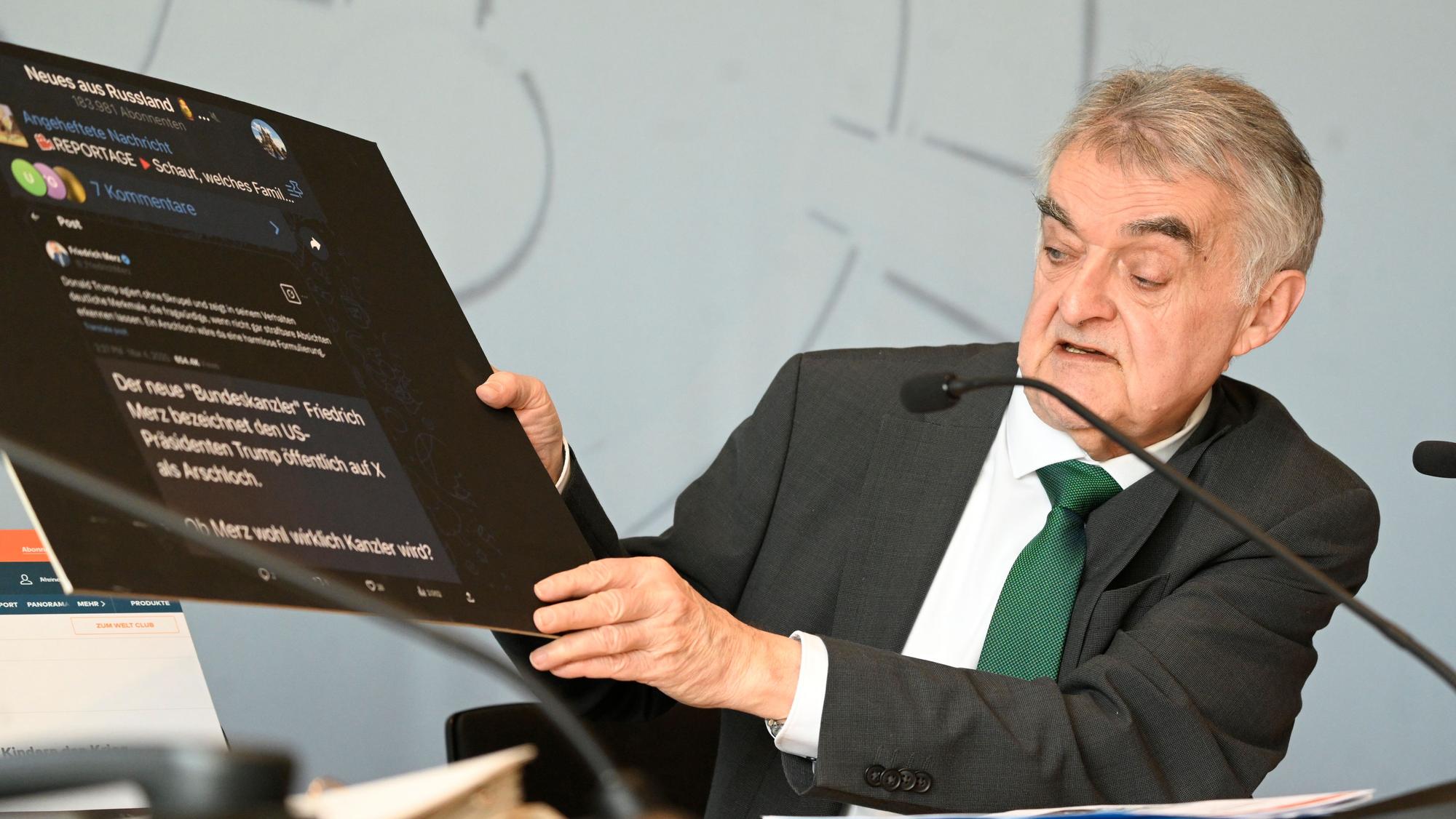 Herbert Reul(CDU), Innenminister von Nordrhein-Westfalen, zeigt eine Tafel mit Fake-Nachrichten aus dem Internet bei der Vorstellung des Verfassungsschutzbericht 2024 des Landes.
