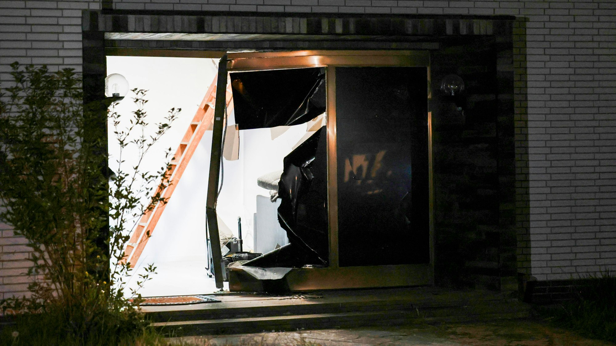 Blick auf den beschädigten Eingang eines Hauses nach einer Durchsuchung durch die Polizei in Pulheim.