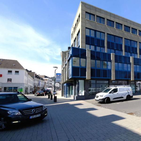 Das Verwaltungsgebäude der VR-Bank Nordeifel in Schleiden. Davor parken einige Autos.
