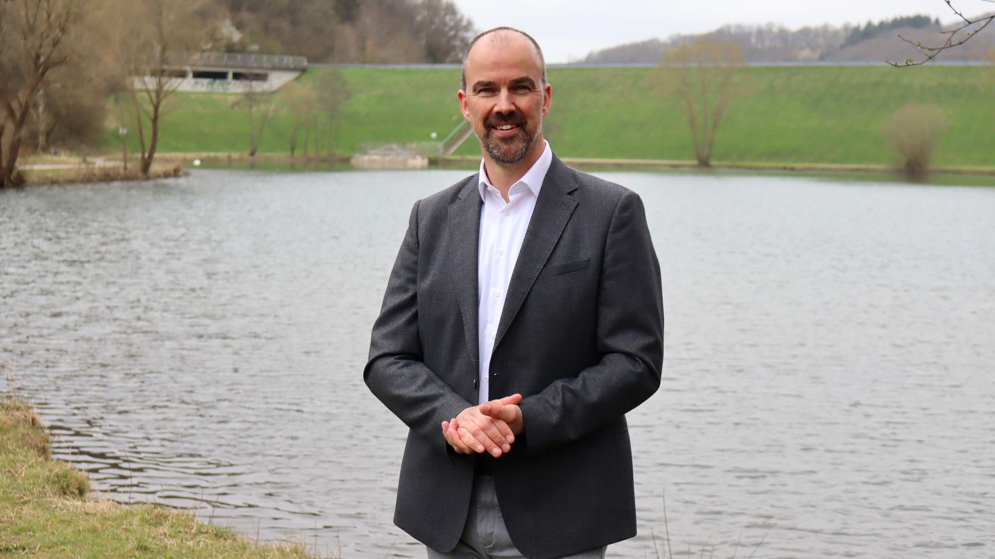 CDU-Bürgermeisterkandidat Guido Waters steht vor dem Rückhaltebecken in Eicherscheid.