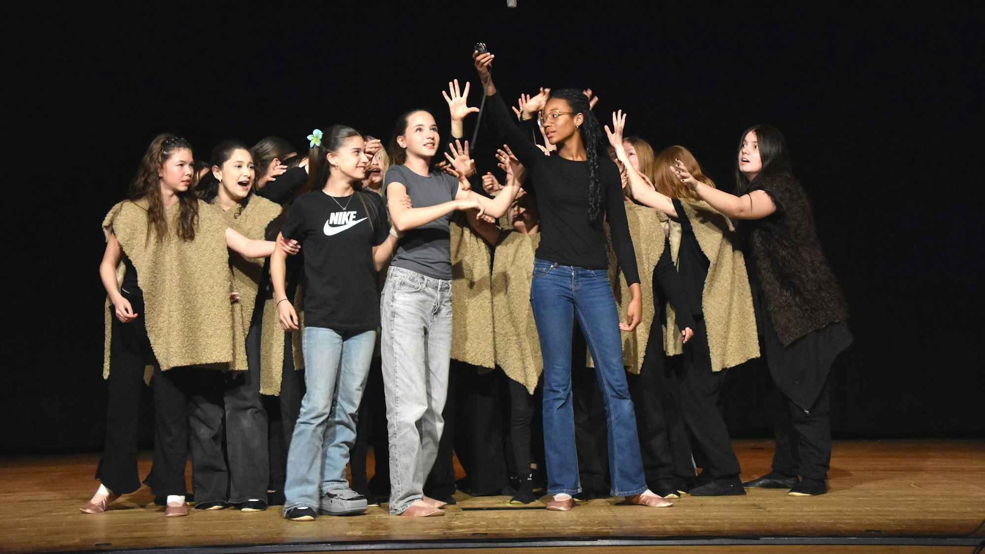 Zu sehen ist eine Gruppe von Schülerinnen auf einer Bühne.