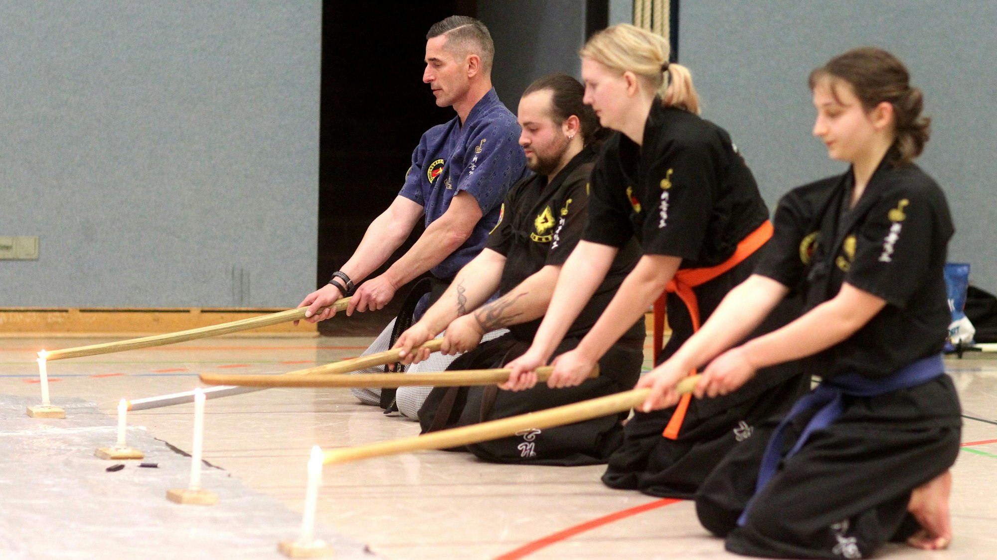 Mit schnell schwingenden Holzschwertern löscht die Gruppe eine Kerze aus.