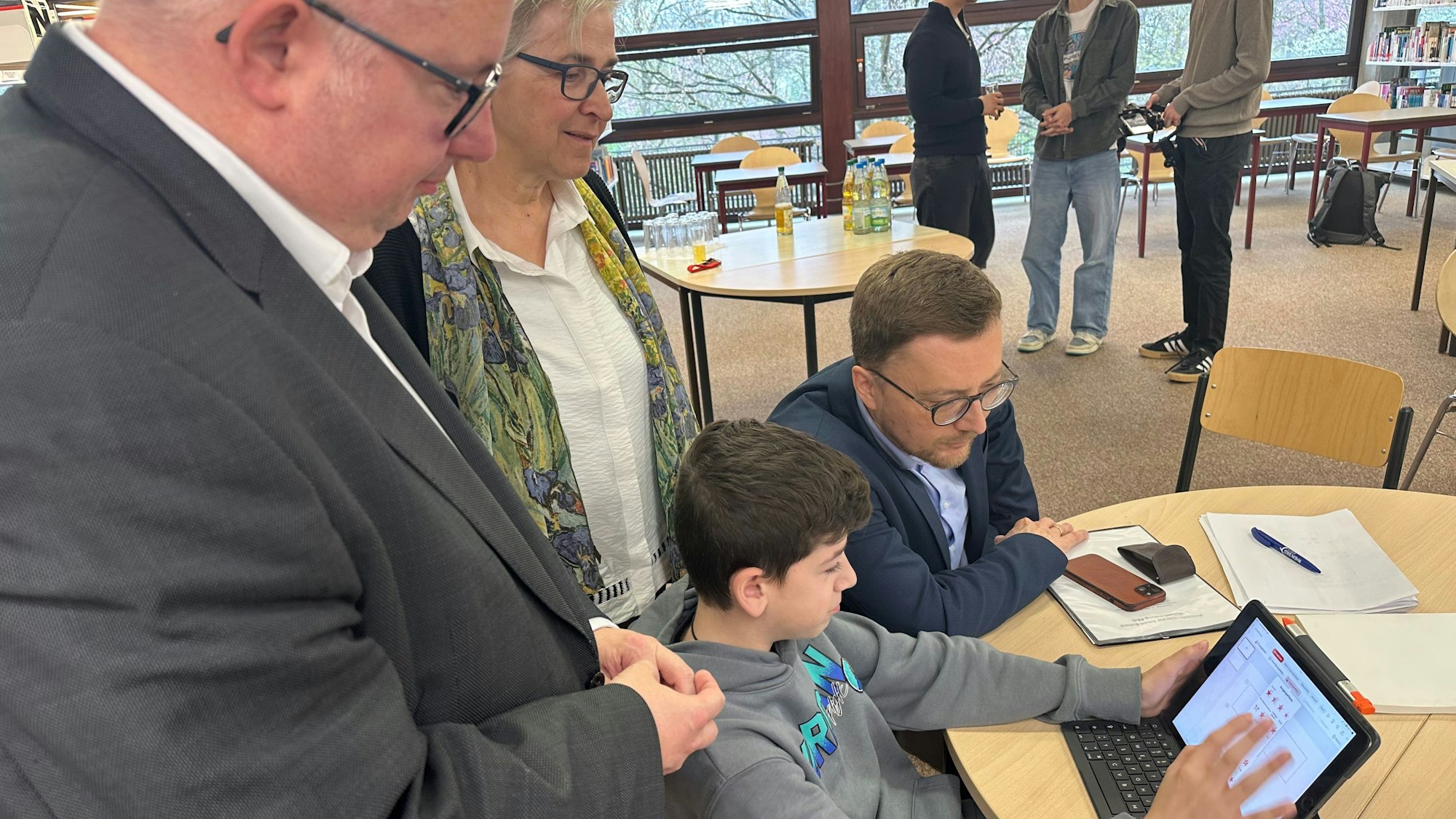Das Albert-Einstein-Gymnasium wurde als smart school ausgezeichnet. Sascha Lienesch, Vorsitzender des Schulausschusses im Rat der Stadt Sankt Augustin; Nicola Thome, stellvertretende Schulleiterin; Walter Eßer, 1. Beigeordneter der Stadt (v.l.) lassen sich von Schüler Azad Lernprogramme erklären.