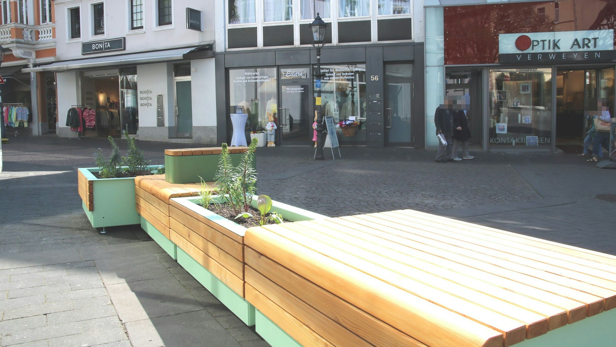 Holzbänke mit integrierten Blumenkästen in der Fußgängerzone.