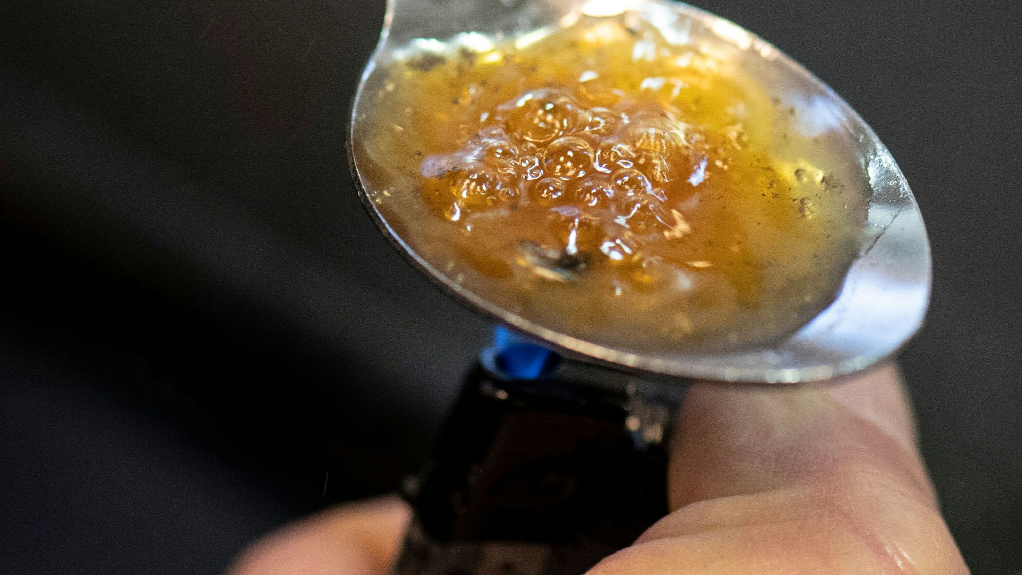 Zubereitung von Heroin auf einem Löffel über einer Flamme