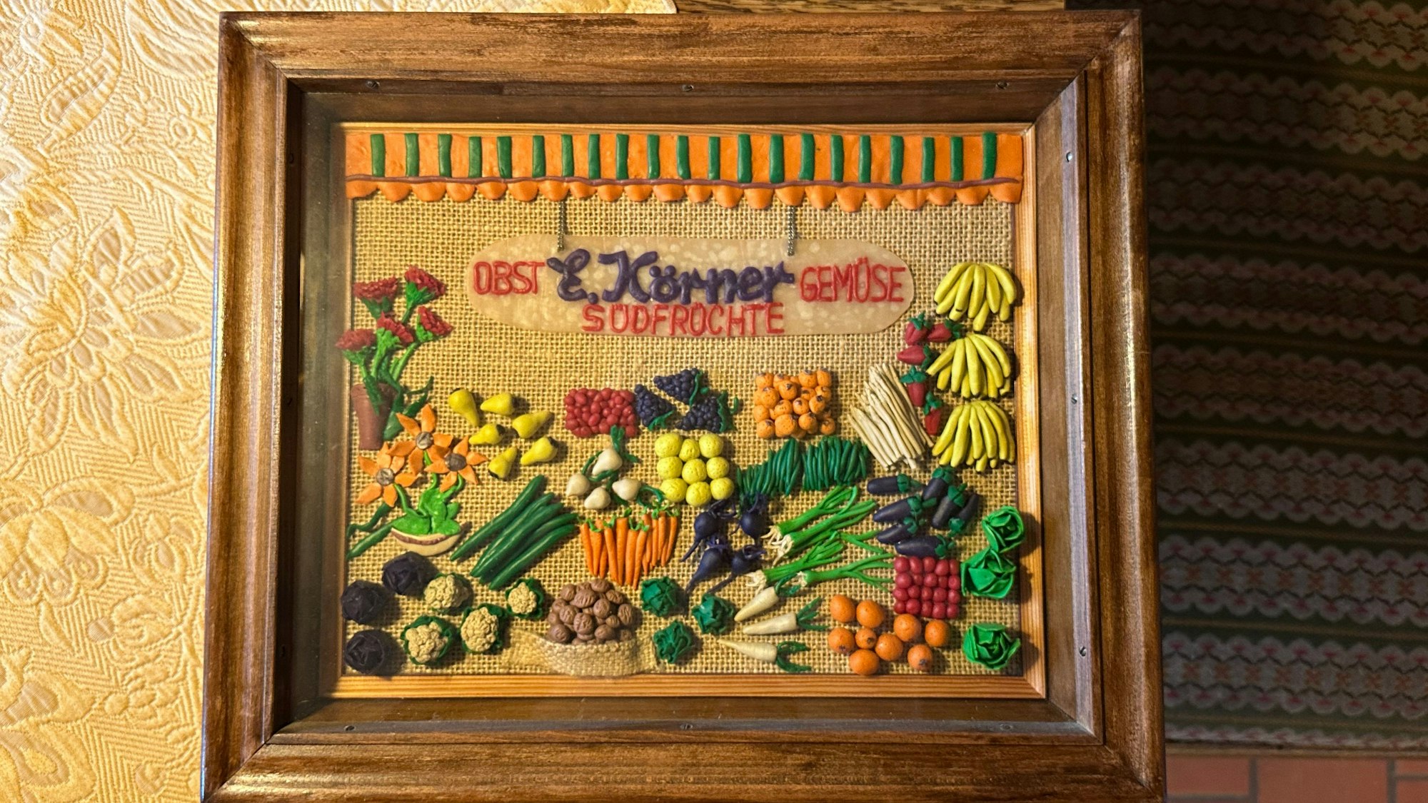 In den Räumen der heutigen Gaststätte Dorfkrug befand sich vorher ein Obst- und Gemüsegeschäft. Dieses Bild aus Knete gefertigt erinnert daran. 23 Jahre lang hatte die Familie Körner den Laden geführt.