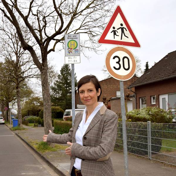 Eine Frau steht vor einer eingezeichneten Parkfläche.