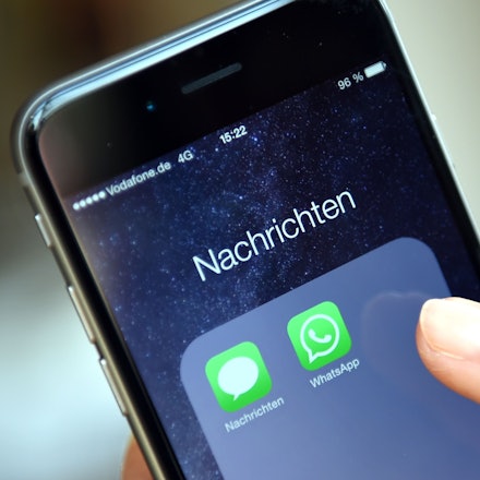 Auf dem Display eines iPhone werden die Symbole der Apps „WhatsApp“ und „Nachrichten“ angezeigt.