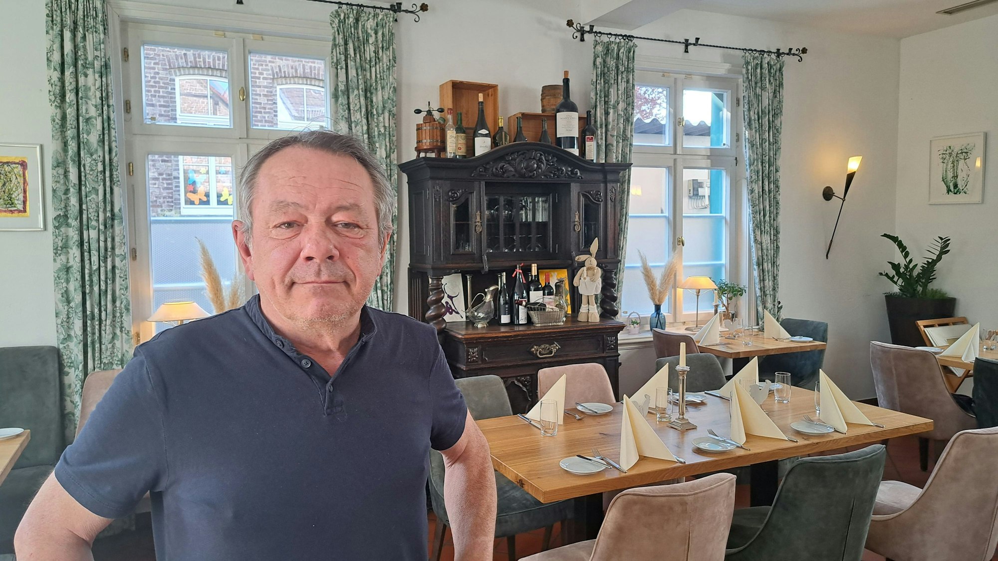 Ein Mann steht im Speiseraum seines Restaurants