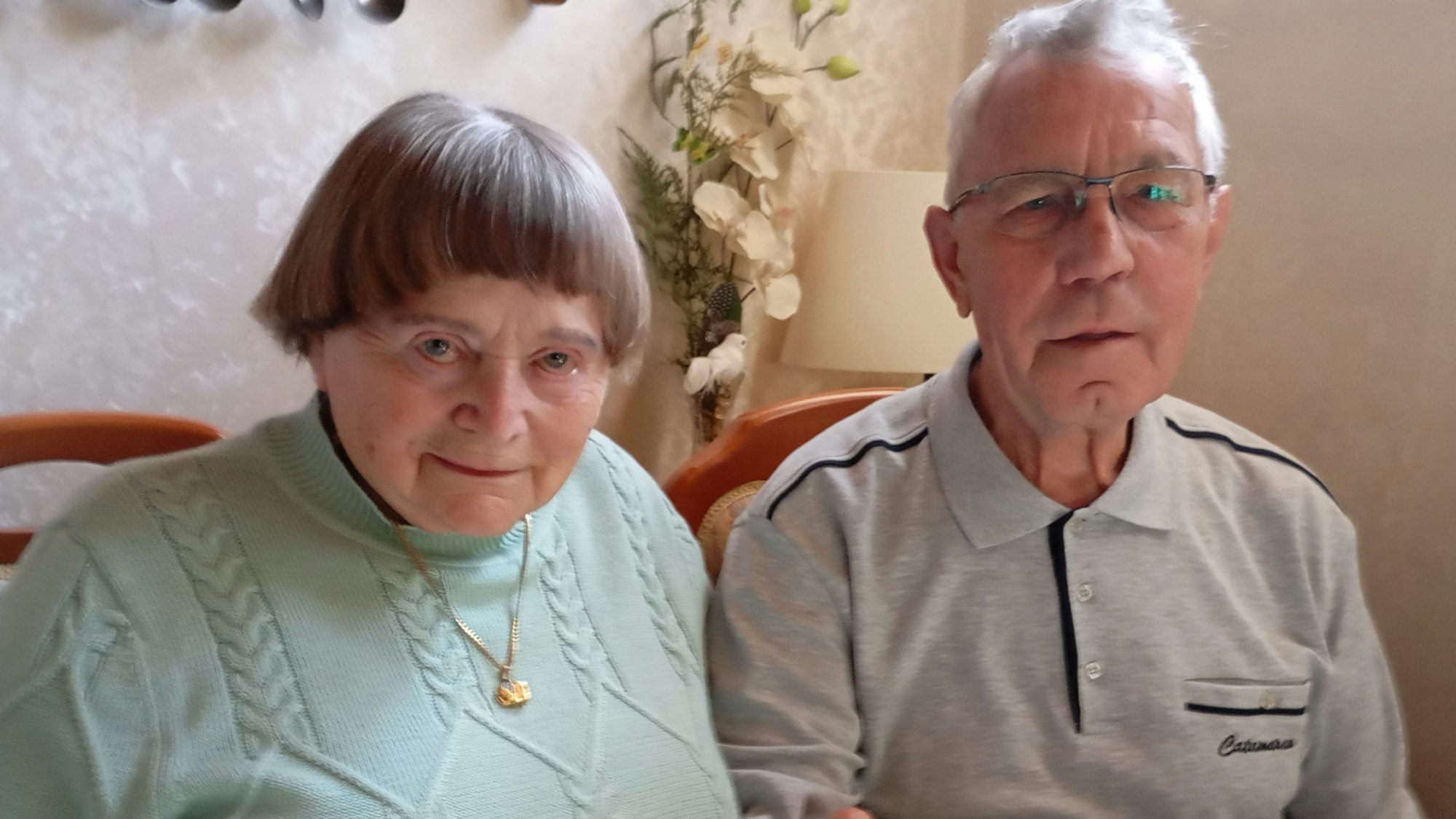 Ein älteres Ehepaar sitzt nebeneinander.
