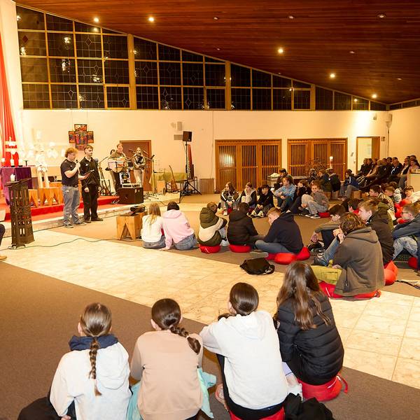 Die rund 60 Teilnehmer sitzen in der Jugendkirche auf Stühlen und auf dem Boden.