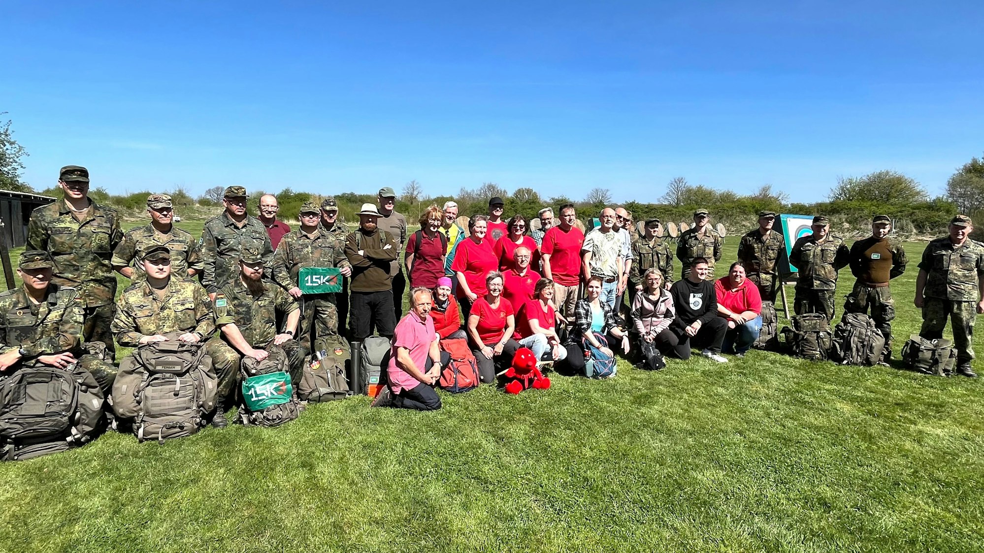 Gruppenfoto mit Soldaten in Uniform und Reservisten, auch Frauen sind dabei.