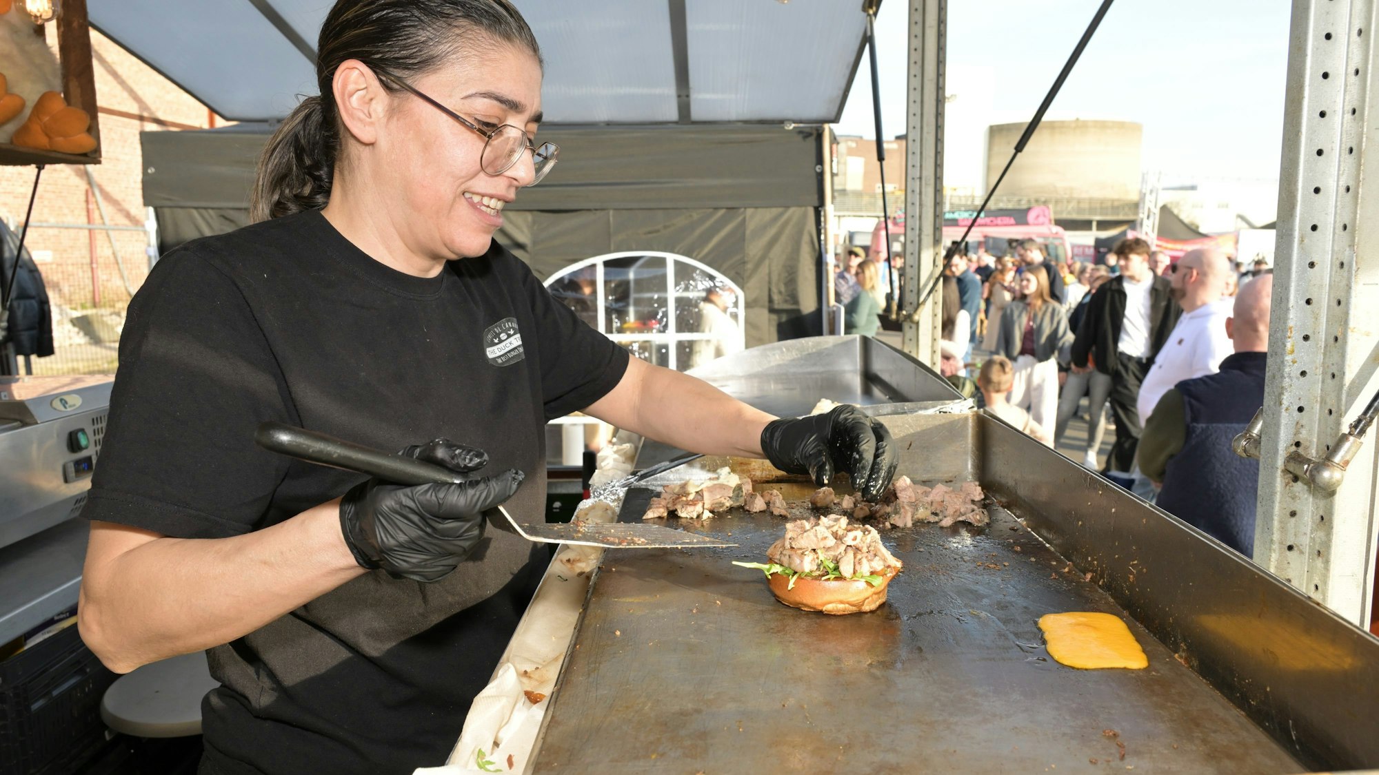 Eine Köchin bereitet einen Burger zu