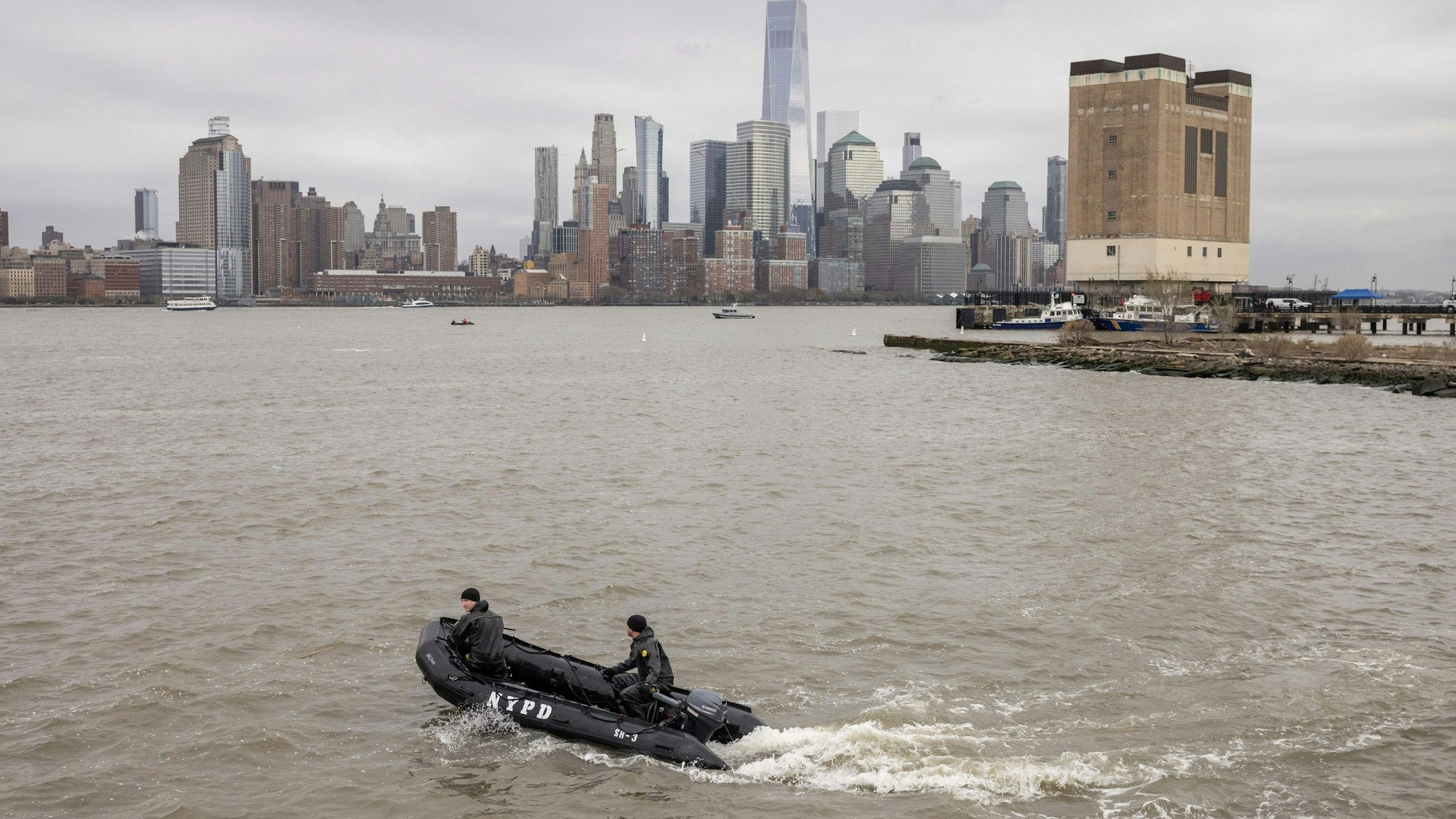 Ein Taucherteam der New Yorker Polizei sucht nach Trümmern an der Stelle, an der ein Rundflug-Hubschrauber am Vortag in den Hudson River in Jersey City, New Jersey, gestürzt ist.