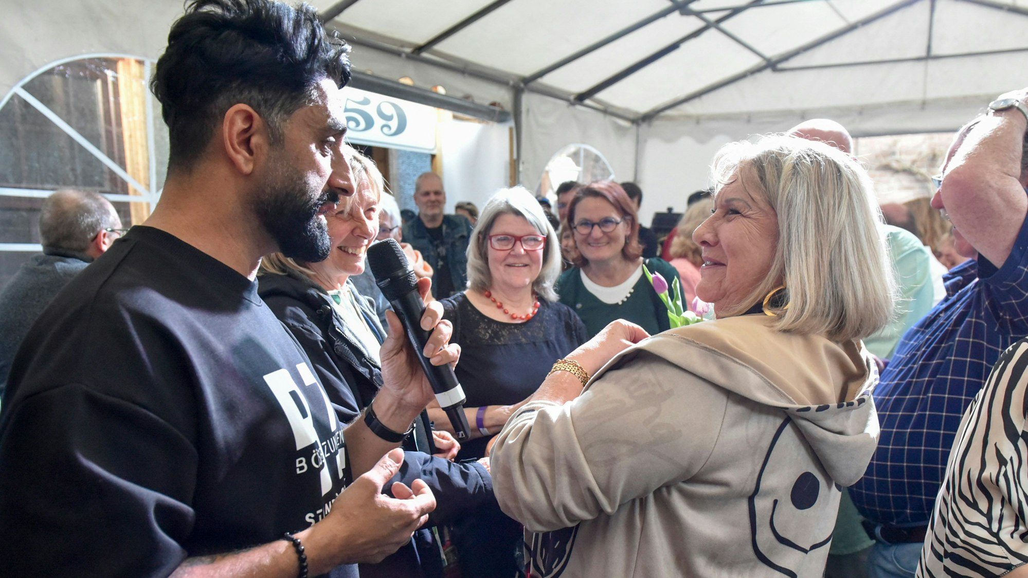 Der Comedian Djavid ist mit einer Frau aus dem Publikum im Zwiegespräch.
