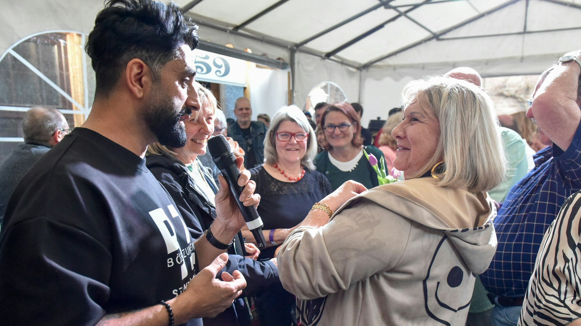 Der Comedian Djavid ist mit einer Frau aus dem Publikum im Zwiegespräch.