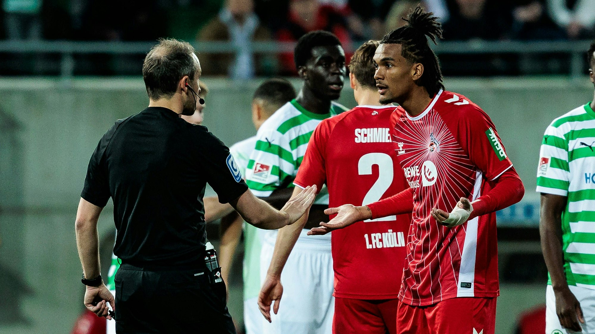 Damion Downs (r.) diskutiert mit Schiedsrichter Patrick Alt über einen möglichen Elfmeter.