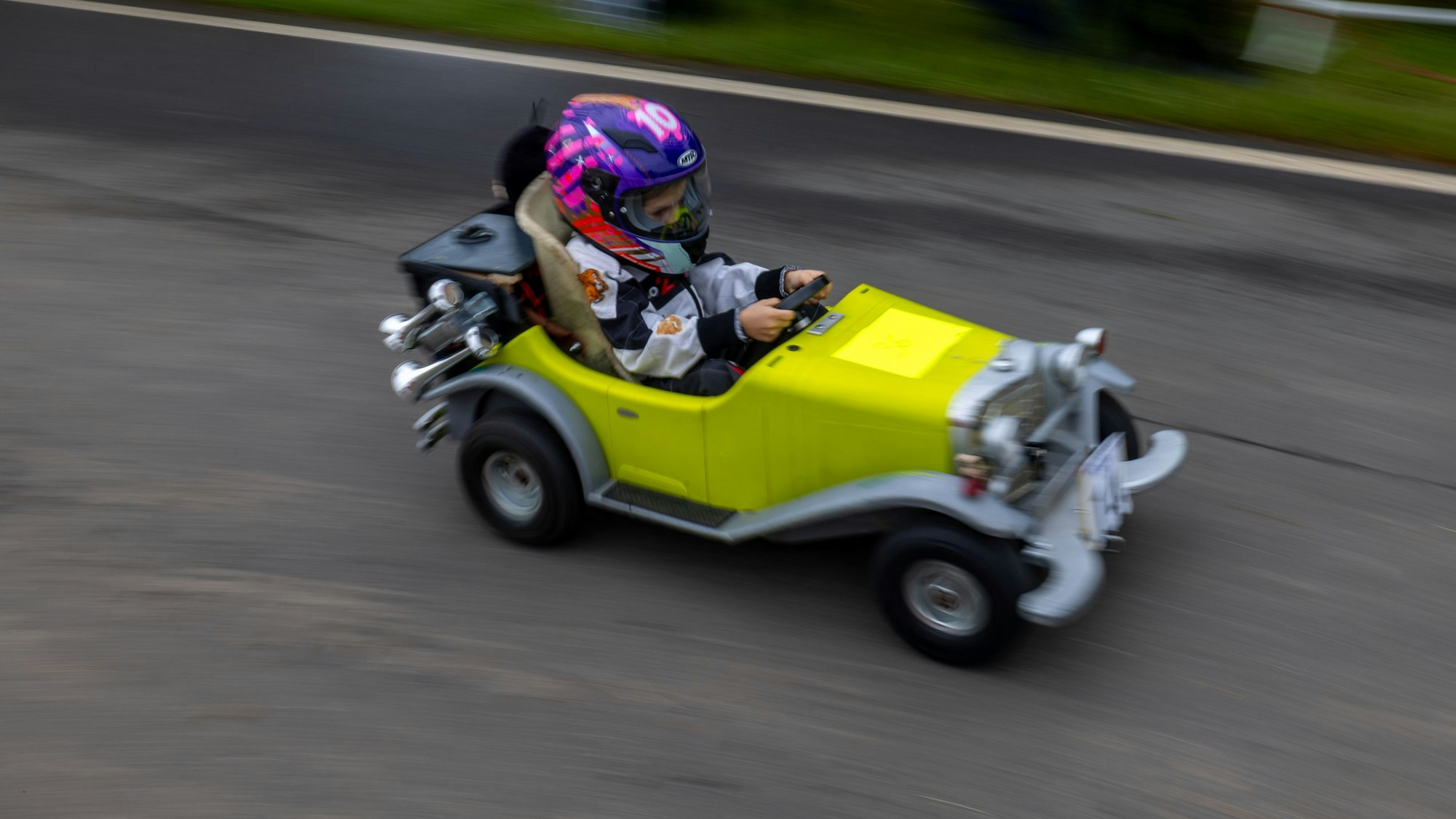 Ein Kind sitzt bei einem Seifenkistenrennen in seinem Fahrzeug.