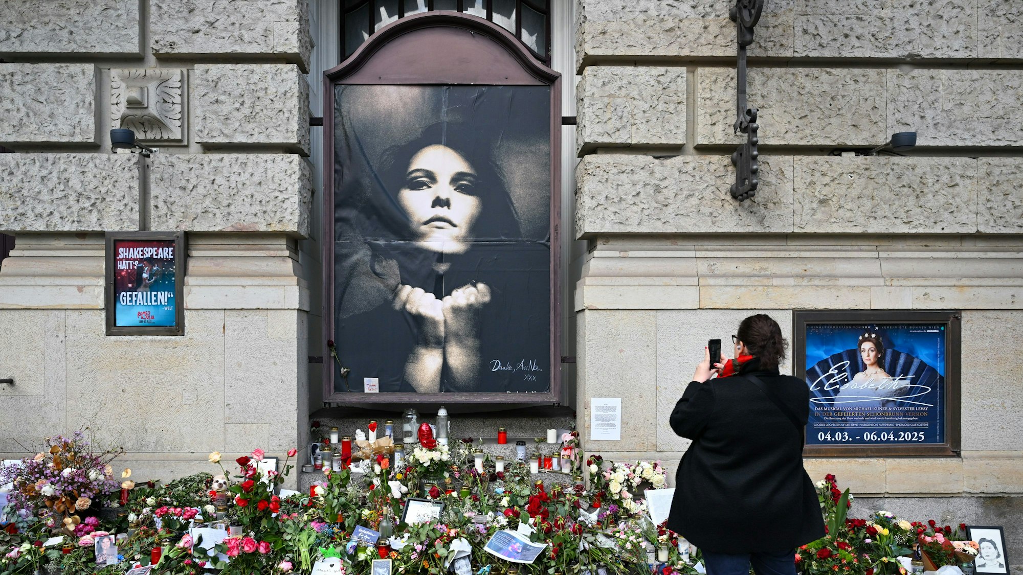 Das Bild zeigt Blumen zum Gedenken an die kürzlich verstorbene Rosenstolz-Sängerin AnNa R. auf dem Fußweg am Theater des Westens.