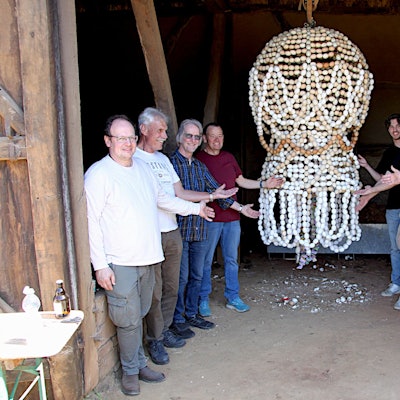 Das Bild zeigt einige Männer, die an der fertig restaurierten Eierkrone stehen.