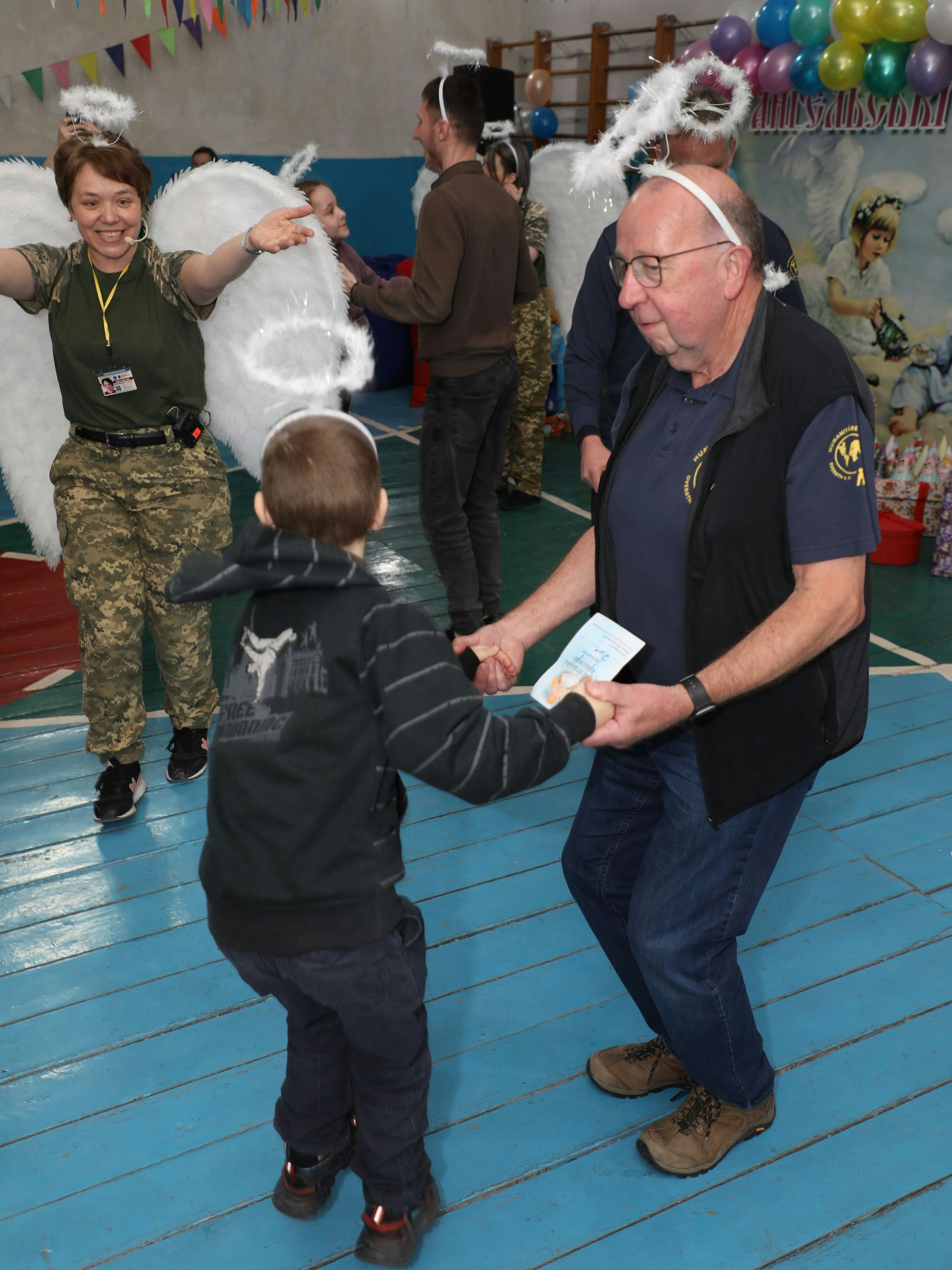 Hilfstransporteur Alfons Clasen tanzt mit einem ukrainischen Kind beim „Engelsfest“ von Ordensschwester Viktoriya Andrushchyshyna (l.) für geflüchtete Kinder in der Ukraine.