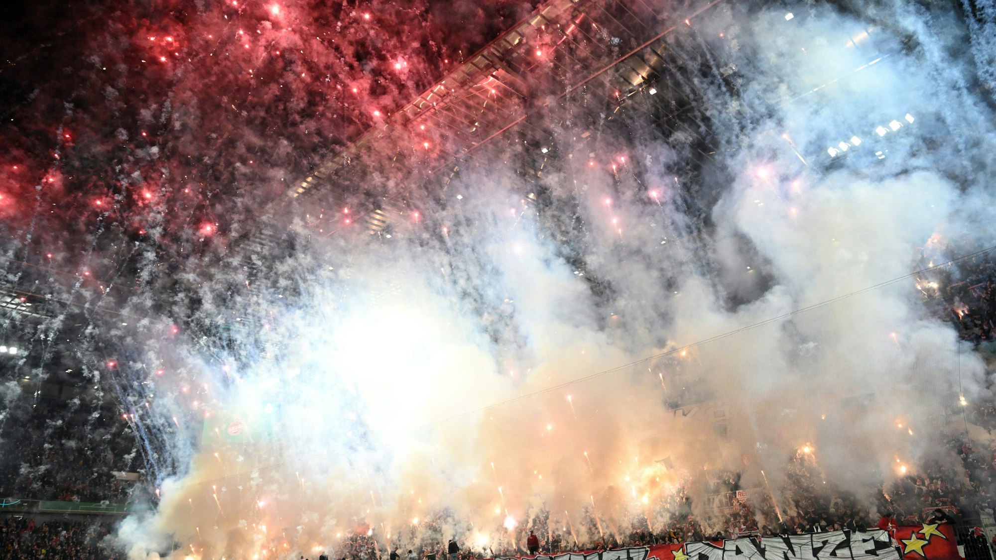04.12.2024, Nordrhein-Westfalen, Köln: Fußball: DFB-Pokal, 1. FC Köln - Hertha BSC Berlin, Achtelfinale, RheinEnergieStadion, Kölns Fans feuern Pyrotechnik ab.