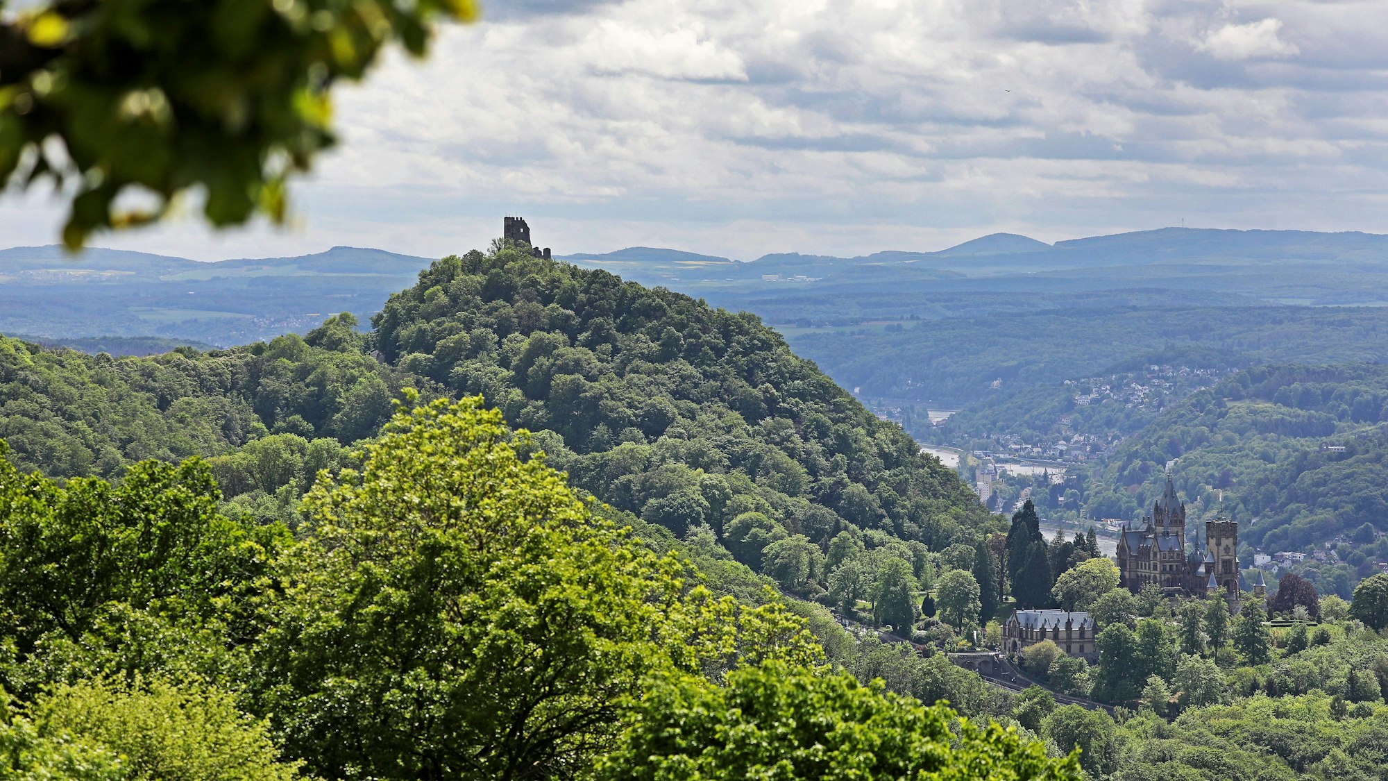 Schloss Drachenburg (r) und Burg Drachenfels sind oberhalb des Rheintals bei Königswinter vom Petersberg aus zu sehen.