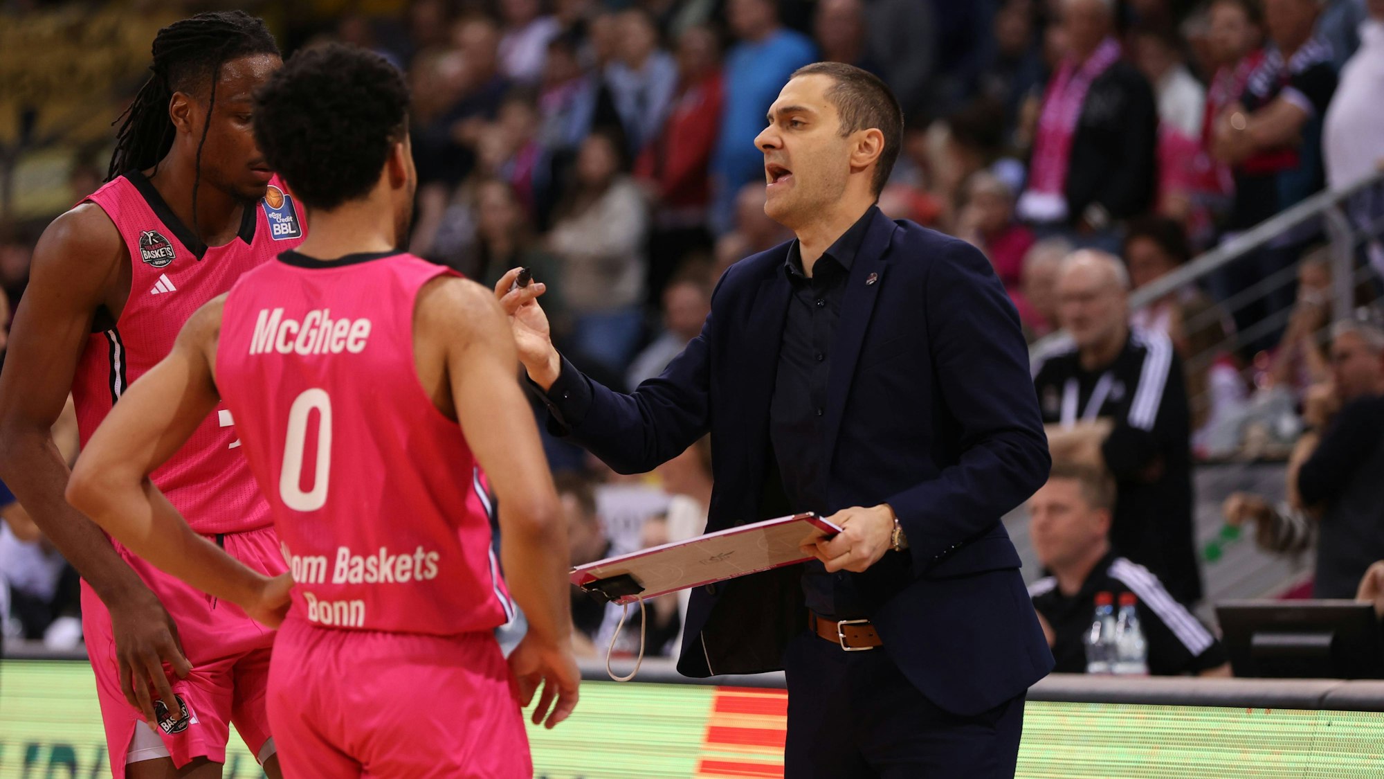 Trainer Marko Stankovic (rechts) teilt Phlandrous Fleming Jr. und Darius McGhee (Mitte) seine Korrekturvorschläge mit.