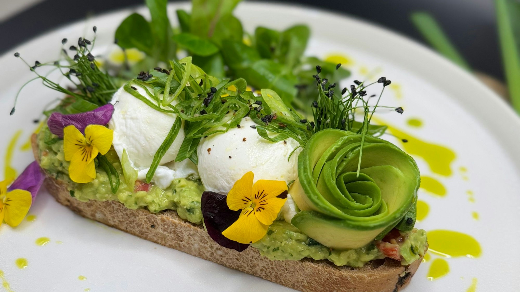 „Grüne Eleganz“ im Whites mit Avocado-Rose, Guacamole und pochiertem Ei.