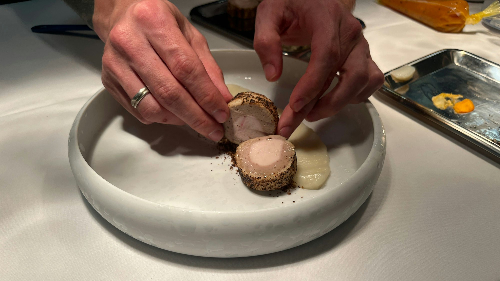 Die Poulardenröllchen werden am Blumenkohlpüree arrangiert.