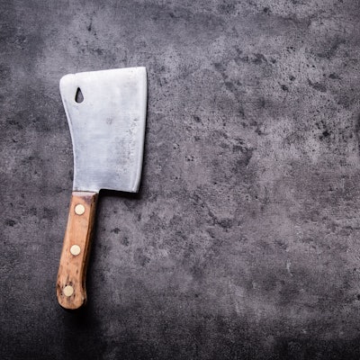 Auf einer grauen Oberfläche liegt ein Hackebeil.