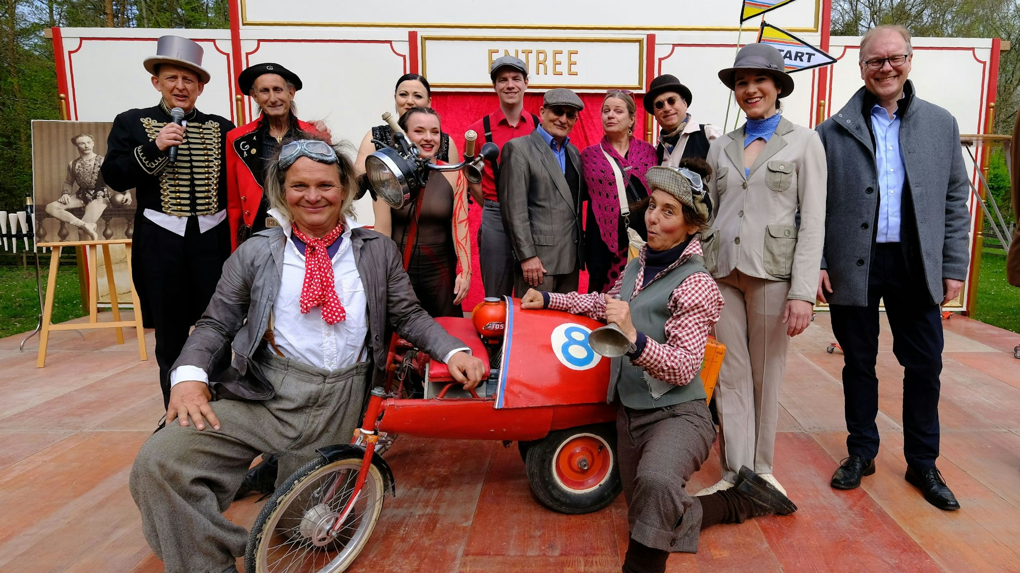 Einige Schausteller, Artisten und Künstler posieren auf der Bühne mit Museumsdirektor Dr. Carsten Vorwig.