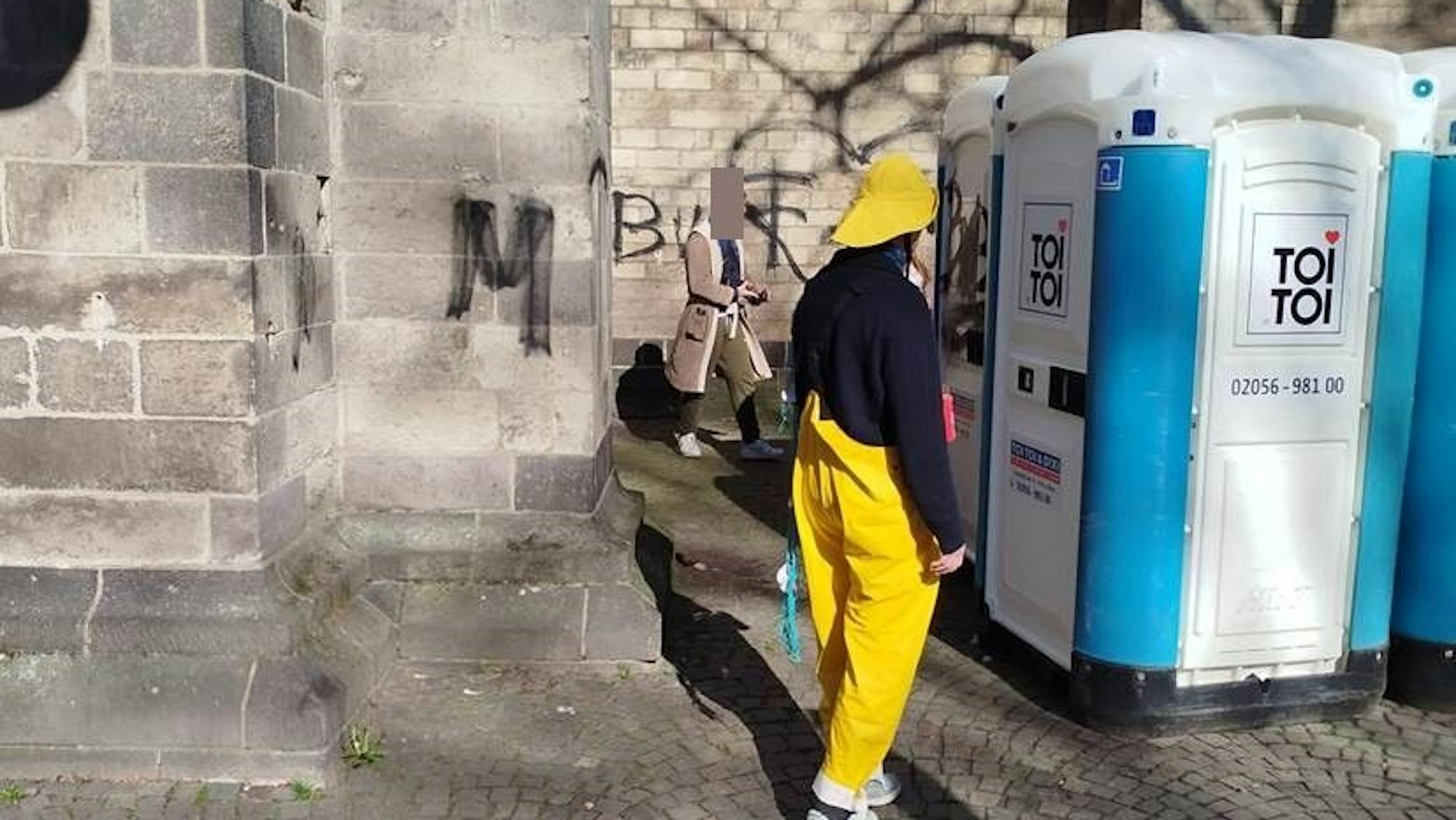 Ein Mann (Hintergrund) besprüht die Minoritenkirche.