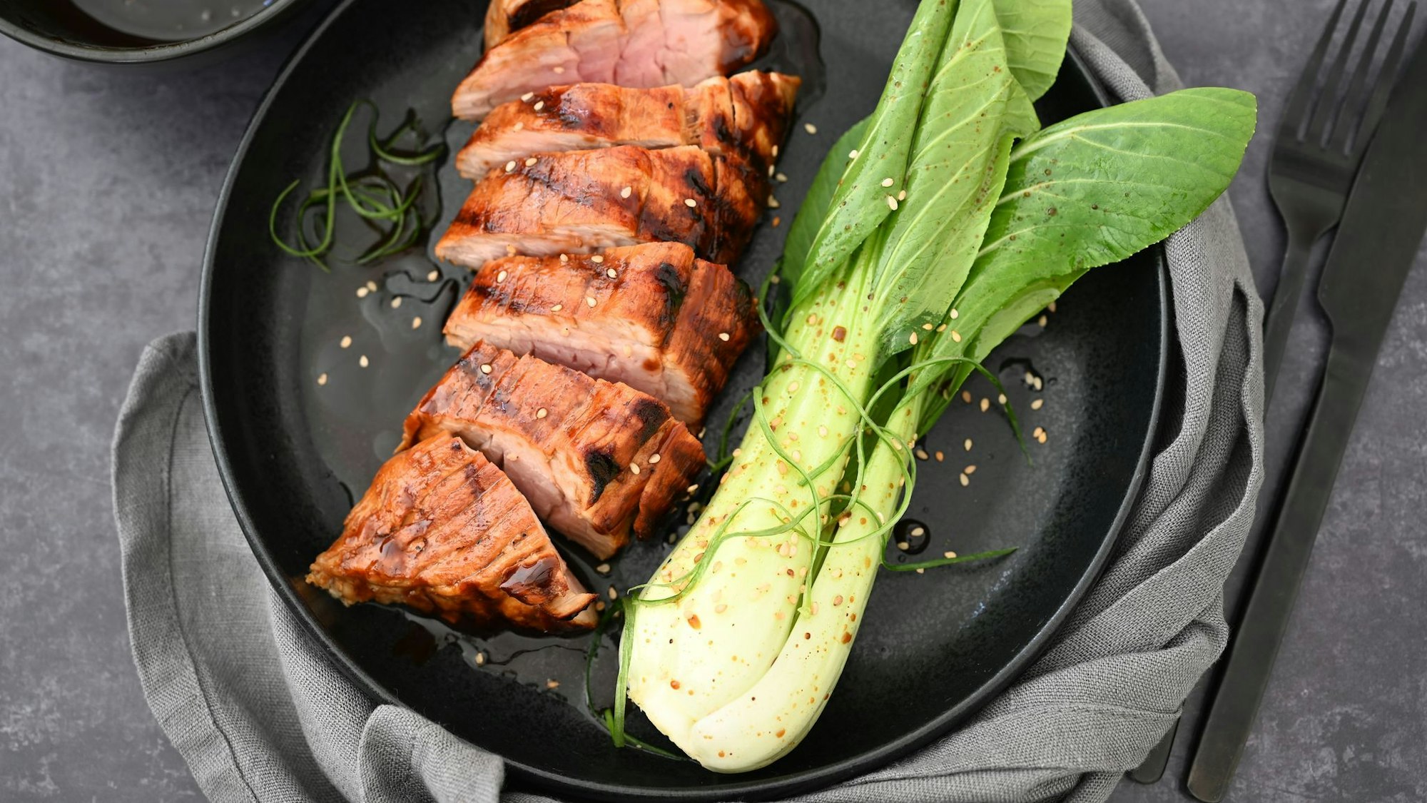 Hoisin-Sauce gibt dem Schweinefilet Würze und eine Karamellnote. Dazu wird Pak Choi serviert.
