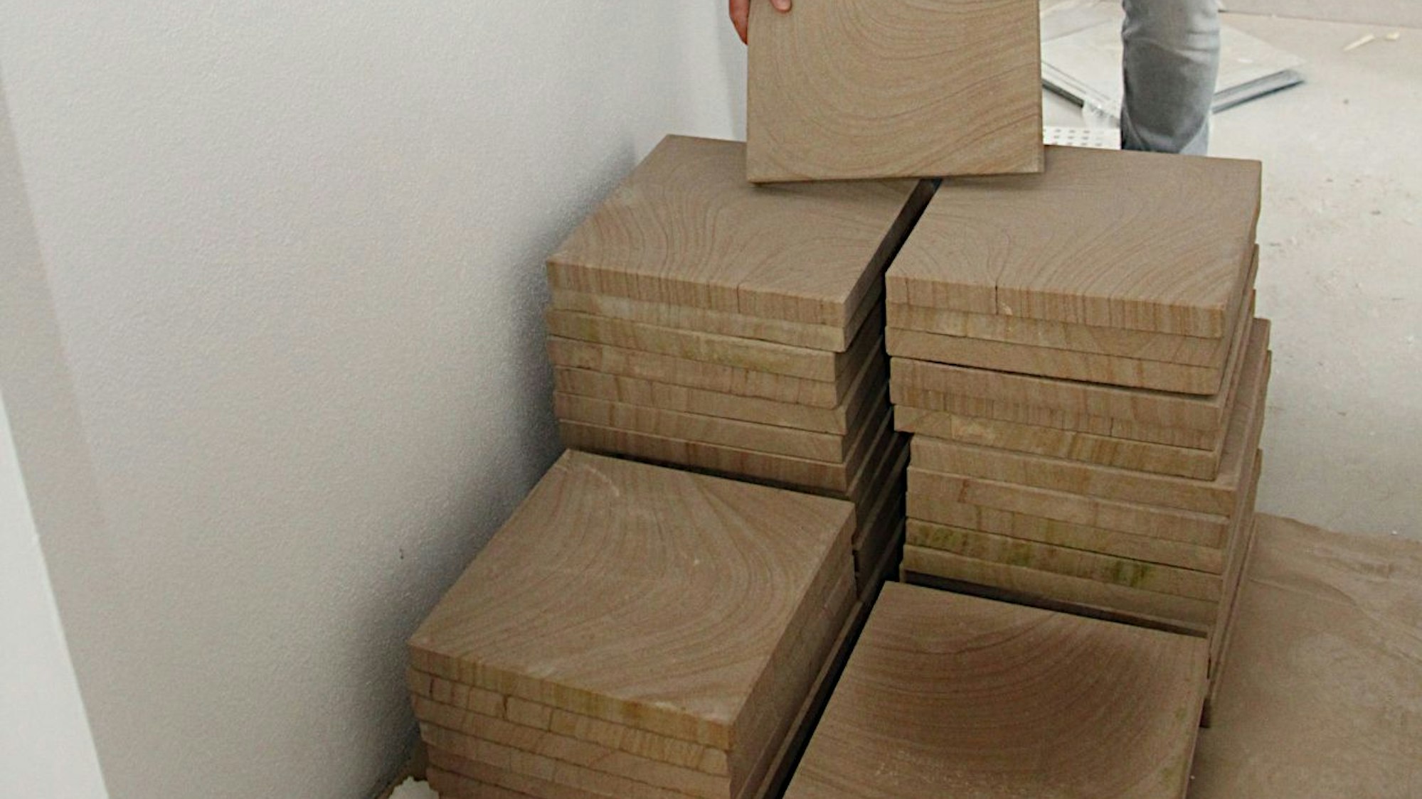 Sandsteinplatten aus dem Kylltal sind aufgestapelt. Sie werden auf dem Boden im Erdgeschoss des neuen Rathauses von Blankenheim verlegt.