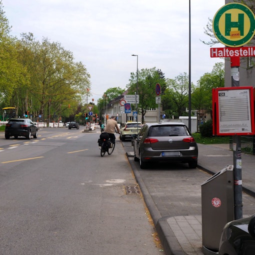 Ein Auto und ein Radfahrer fahren auf dem Raderberggürtel in Marienburg