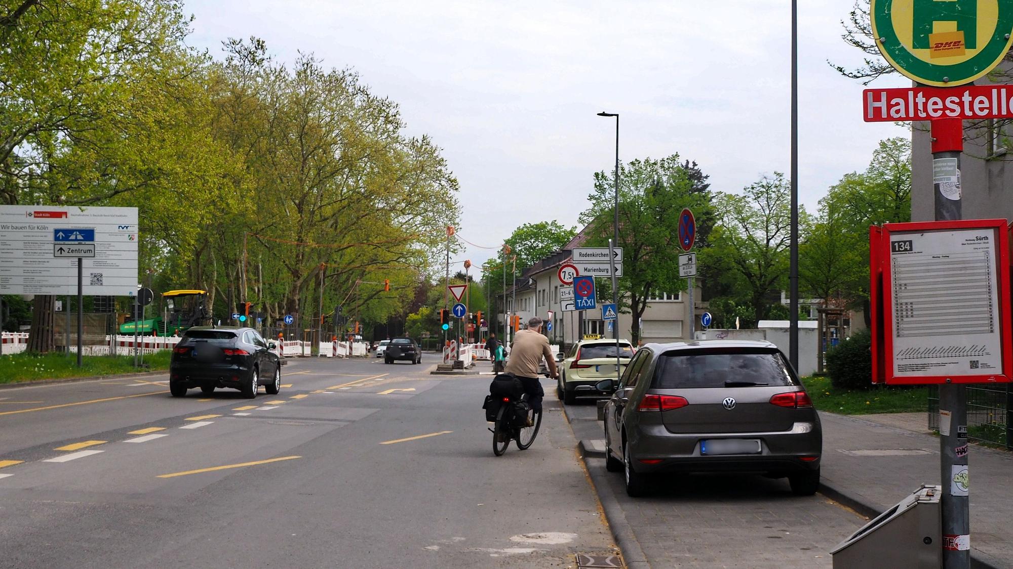 Ein Auto und ein Radfahrer fahren auf dem Raderberggürtel in Marienburg