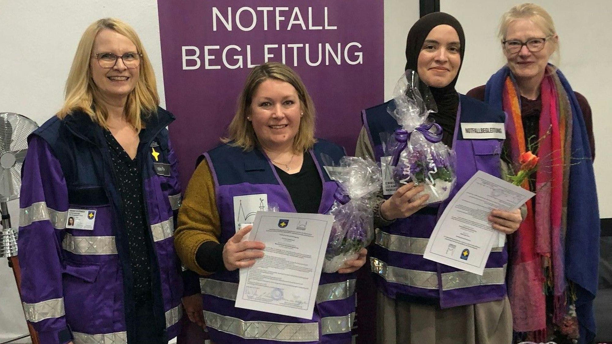 Mehrere Frauen stehen nebeneinander. Zeei halten ein Zertifikat in den Händen.