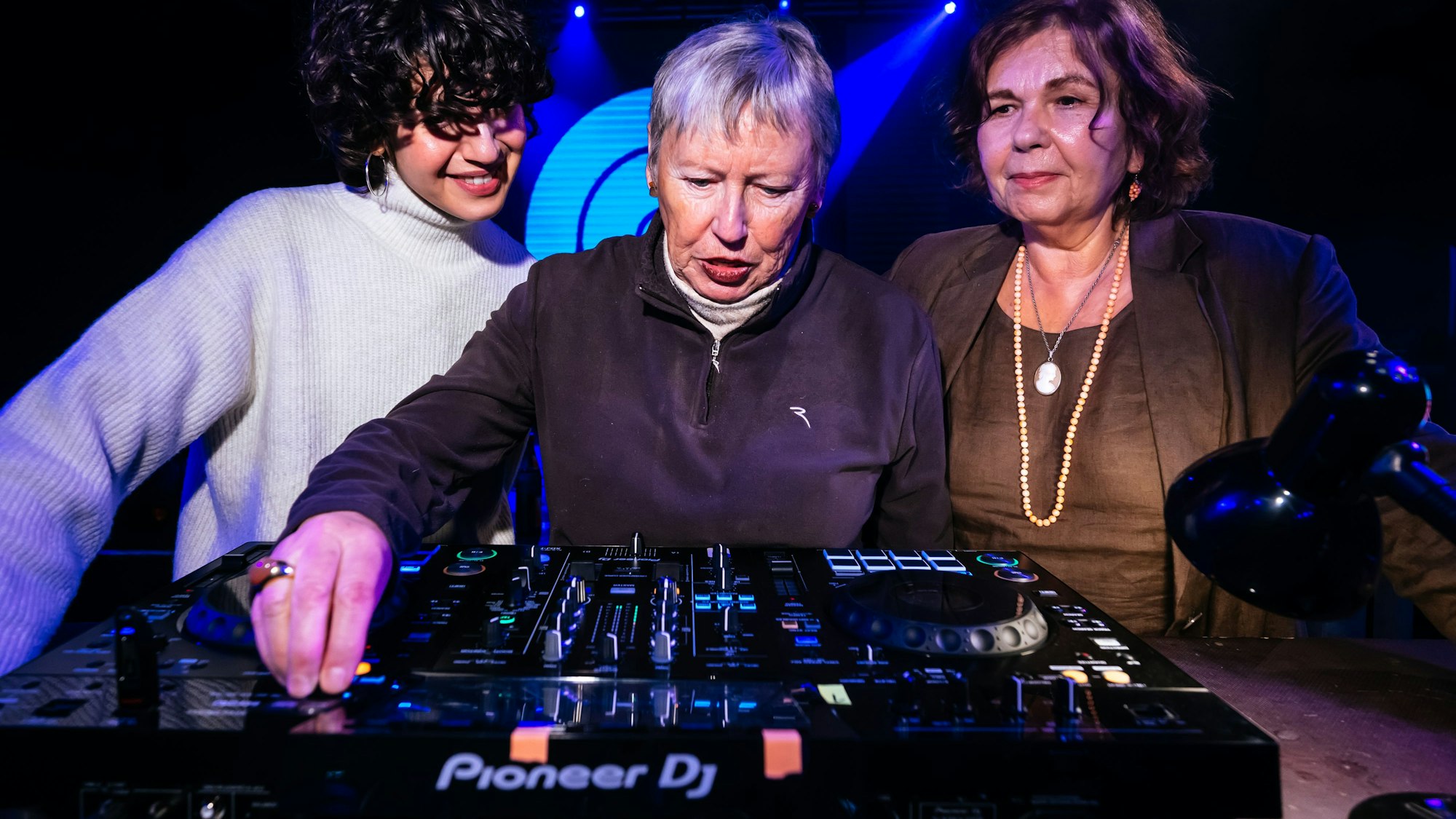 Die 79-jährige Inge Dobrinski (M.) und Ingrid Jatho (r.) lernen von einer DJ-Dozentin neue Fähigkeiten am Mischpult.