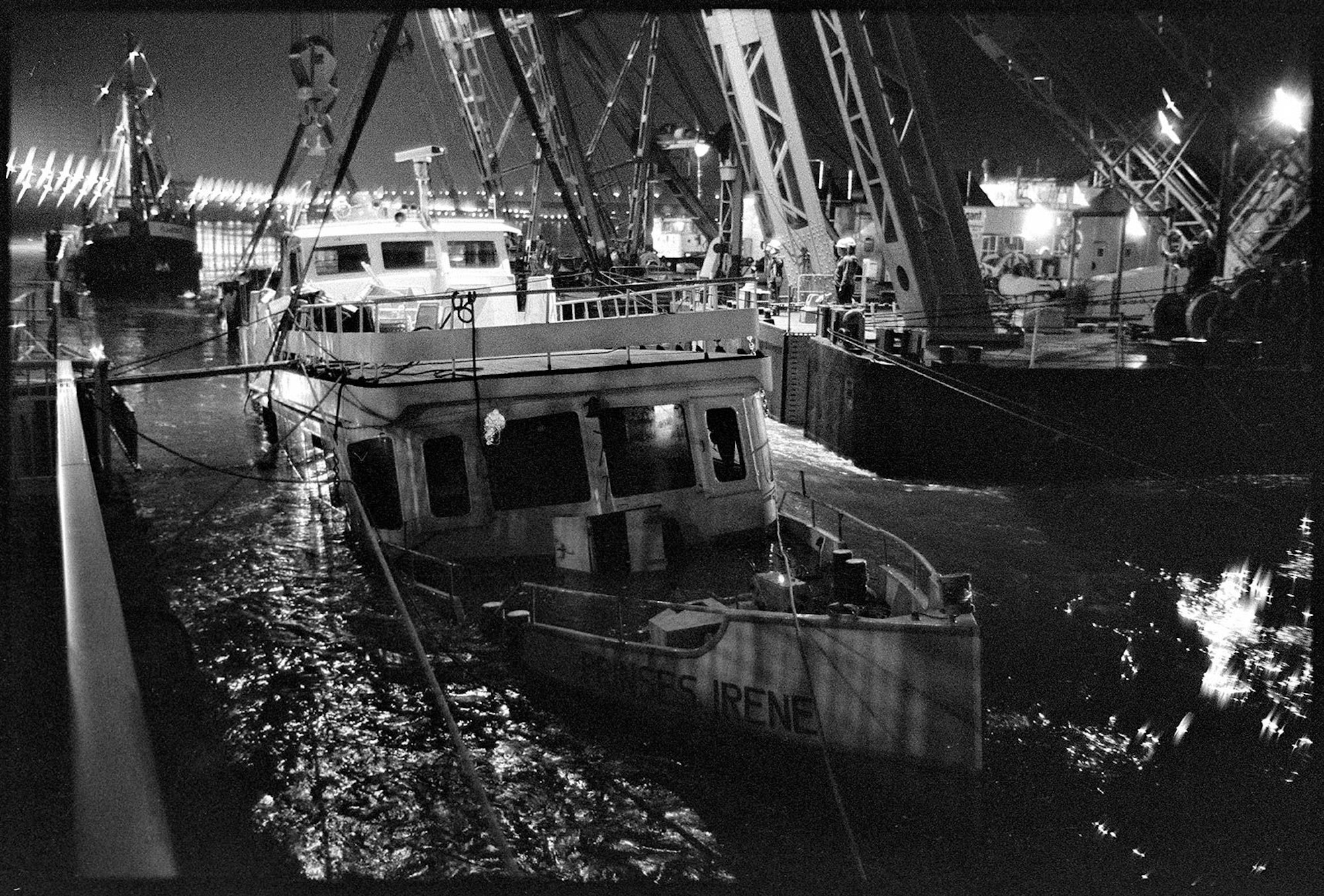 Das gesunkene Schiff ragt während der Bergung halb aus dem Wasser.