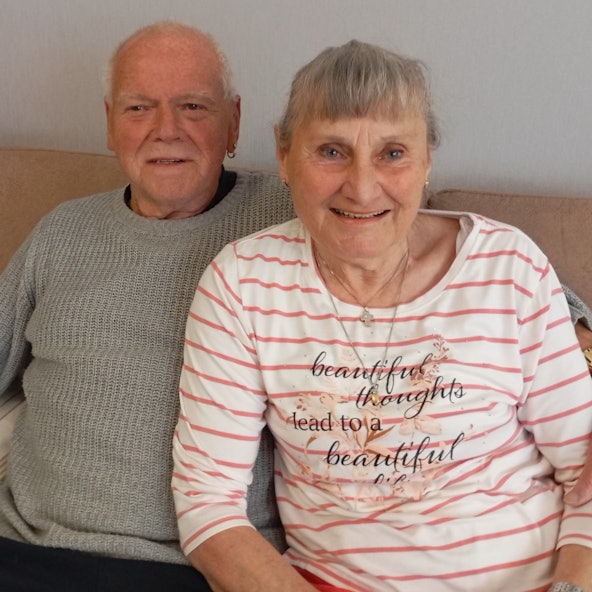 Ein Ehepaar sitzt auf seiner Couch.