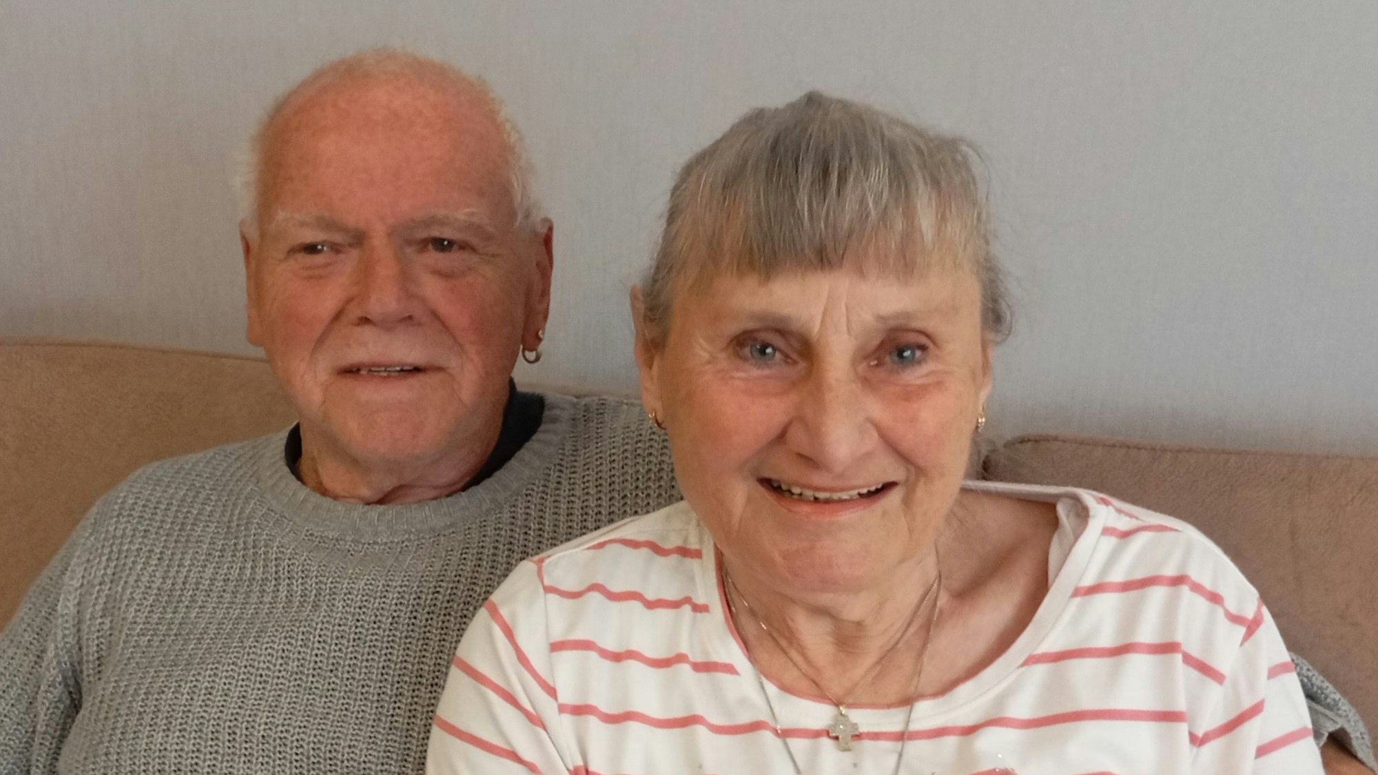 Ein Ehepaar sitzt auf seiner Couch.