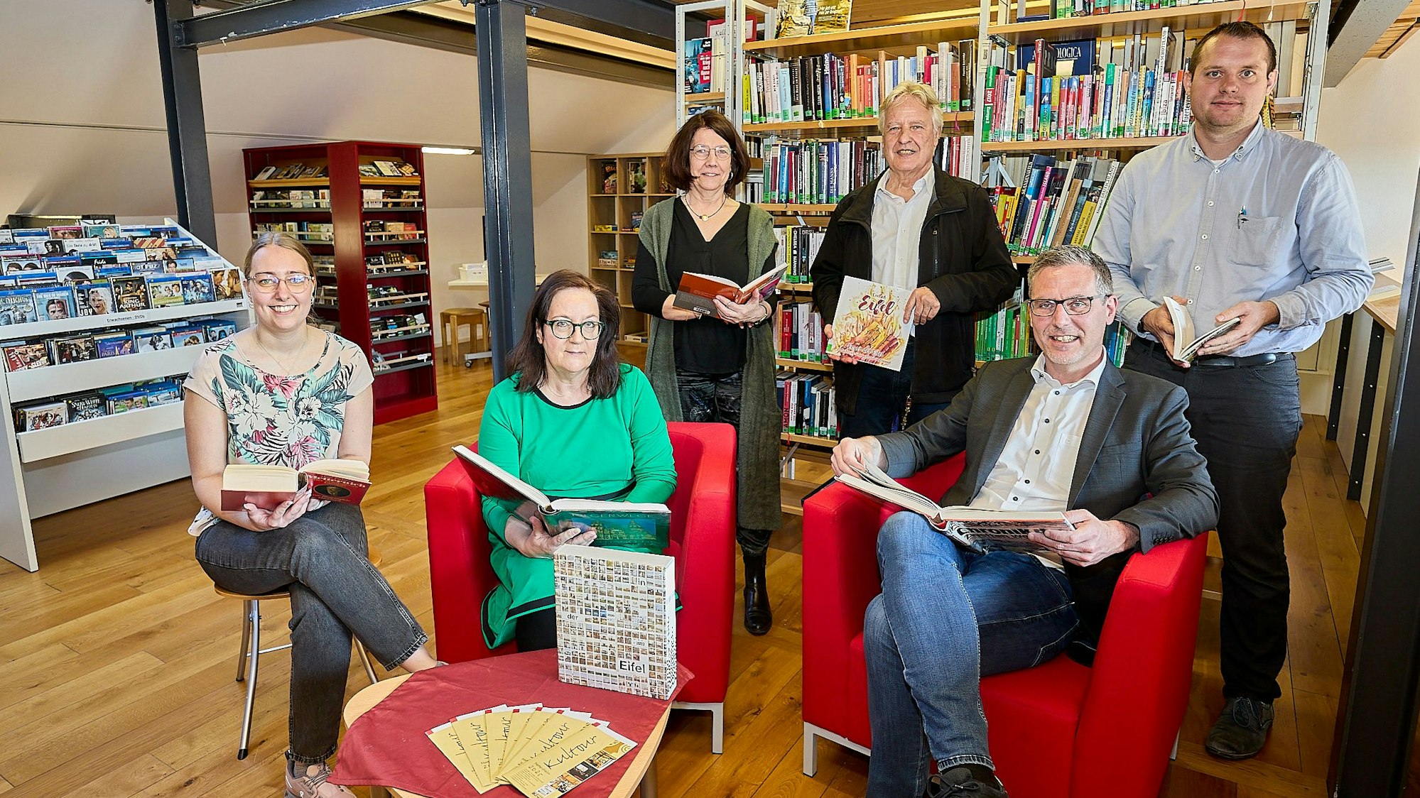 Lea Blindert, Brigitte Wies, Uschi Mießeler, Jochen Starke, Norbert Crump und Alexander Mauel haben sich mit Büchern in der Gemeindebibliothek postiert.