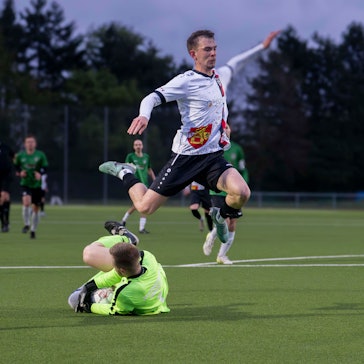 Das Bild zeigt Schulz, der über den Torhüter springt, der den Ball unter sich begräbt.