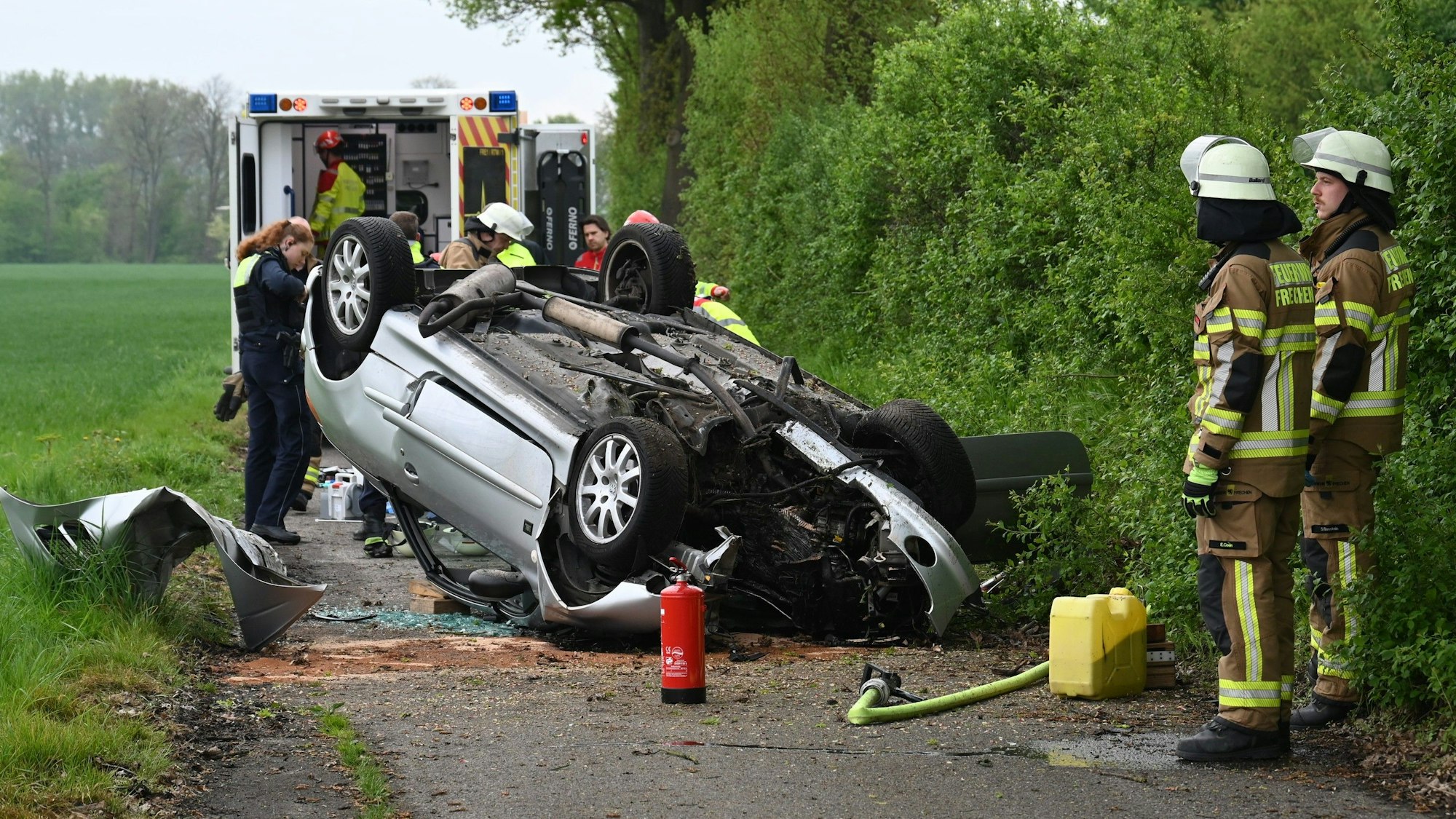 Das Bild zeigt einen Wagen, der auf dem Dach liegt und mehrere Einsatzkräfte.