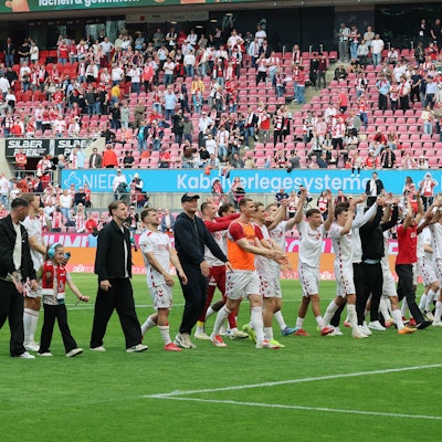 Mit Kind und Kegel und den verletzten Spielern: Die Mannschaft des 1. FC Köln feiert nach dem Spiel vor der Südtribüne.
